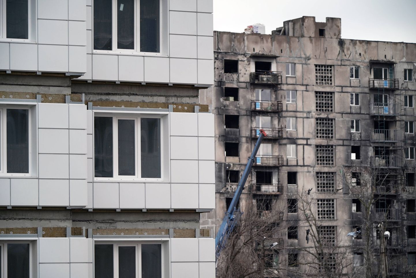 Sõjas kannatada saanud korrusmaja ja uus kortermaja Ukrainas Mariupolis, mis on alates 2022. aastast Vene vägede kontrolli all.
