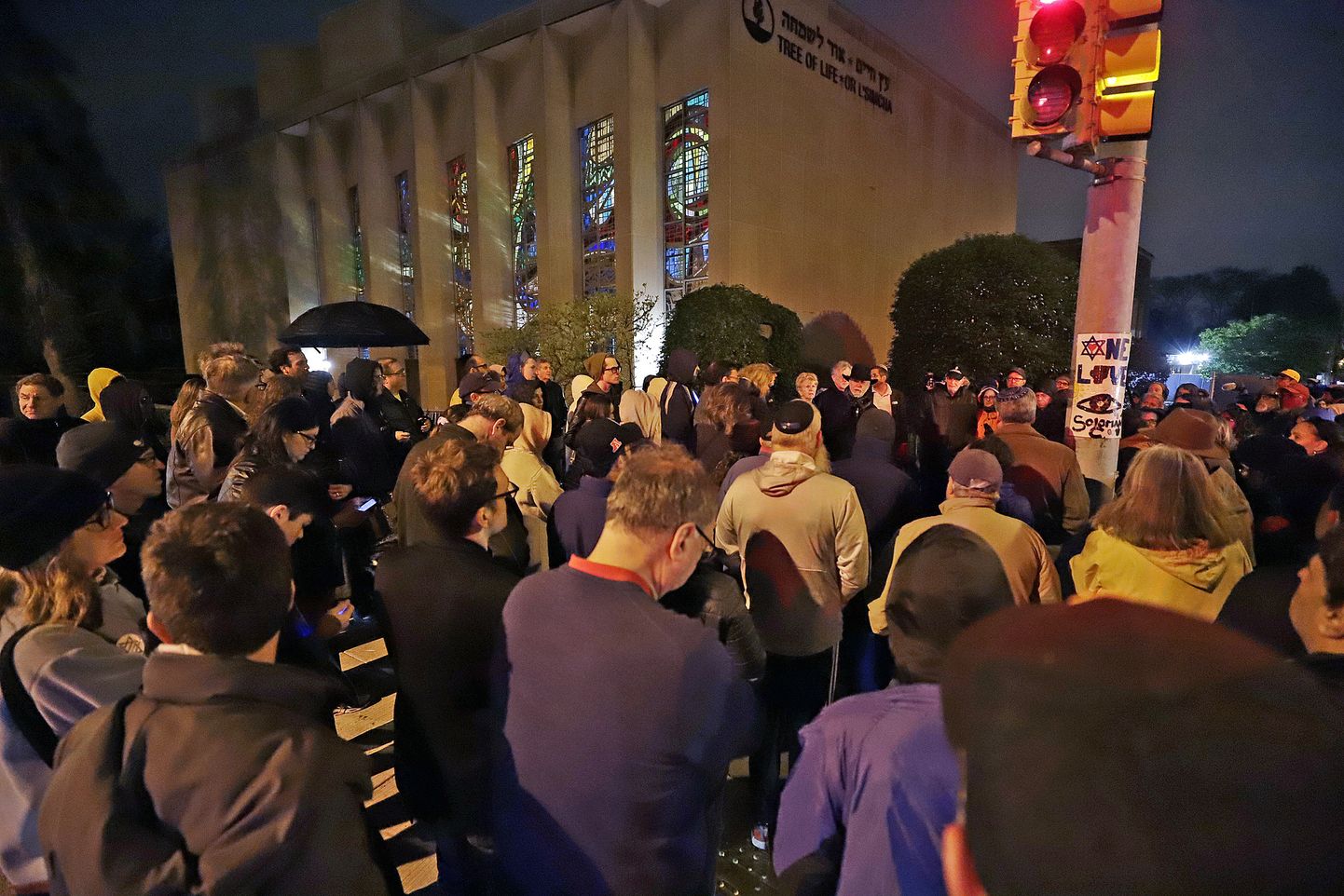Cilvēki pulcējas pie sinagogas, lai pieminētu apšaudē cietušos. 