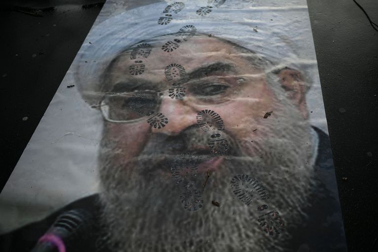 Iraani president Hassan Rouhani pildiga plakatit katavad jalajäljed.