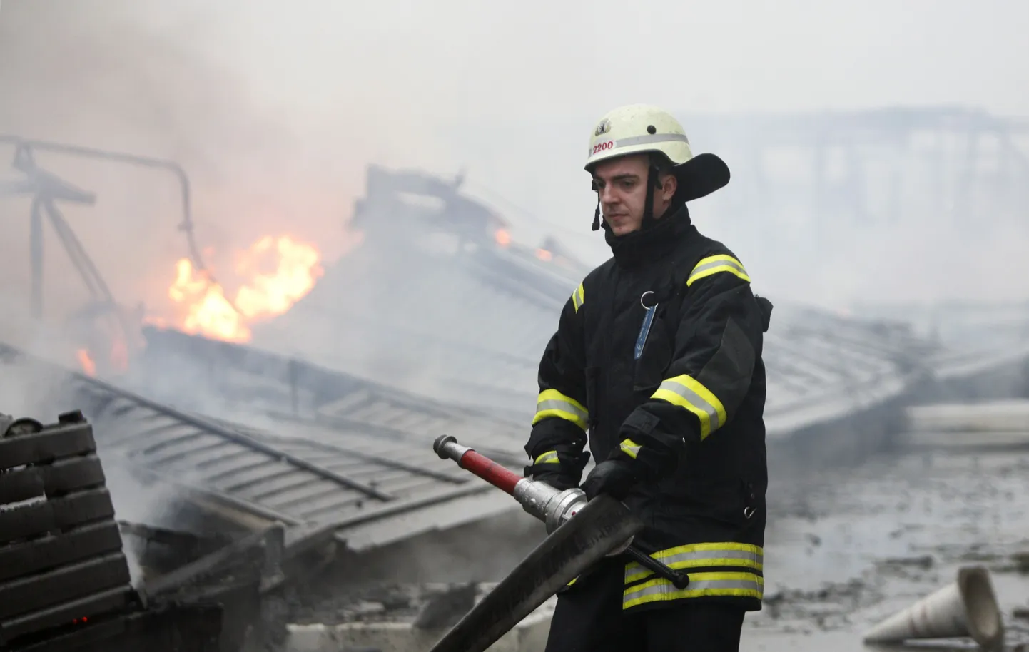 Tegeli lennujaama tuletõrjujad kustutamas tühjalt seisnud karantiinihoonet, milles puhkenud tulekahju peatas mõneks ajaks õhuliikluse.