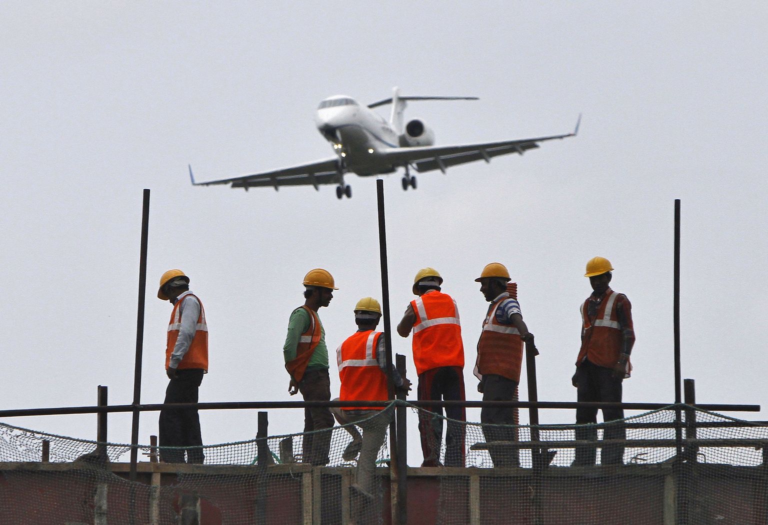 Maanduv Air India lennuk tööliste taustal.