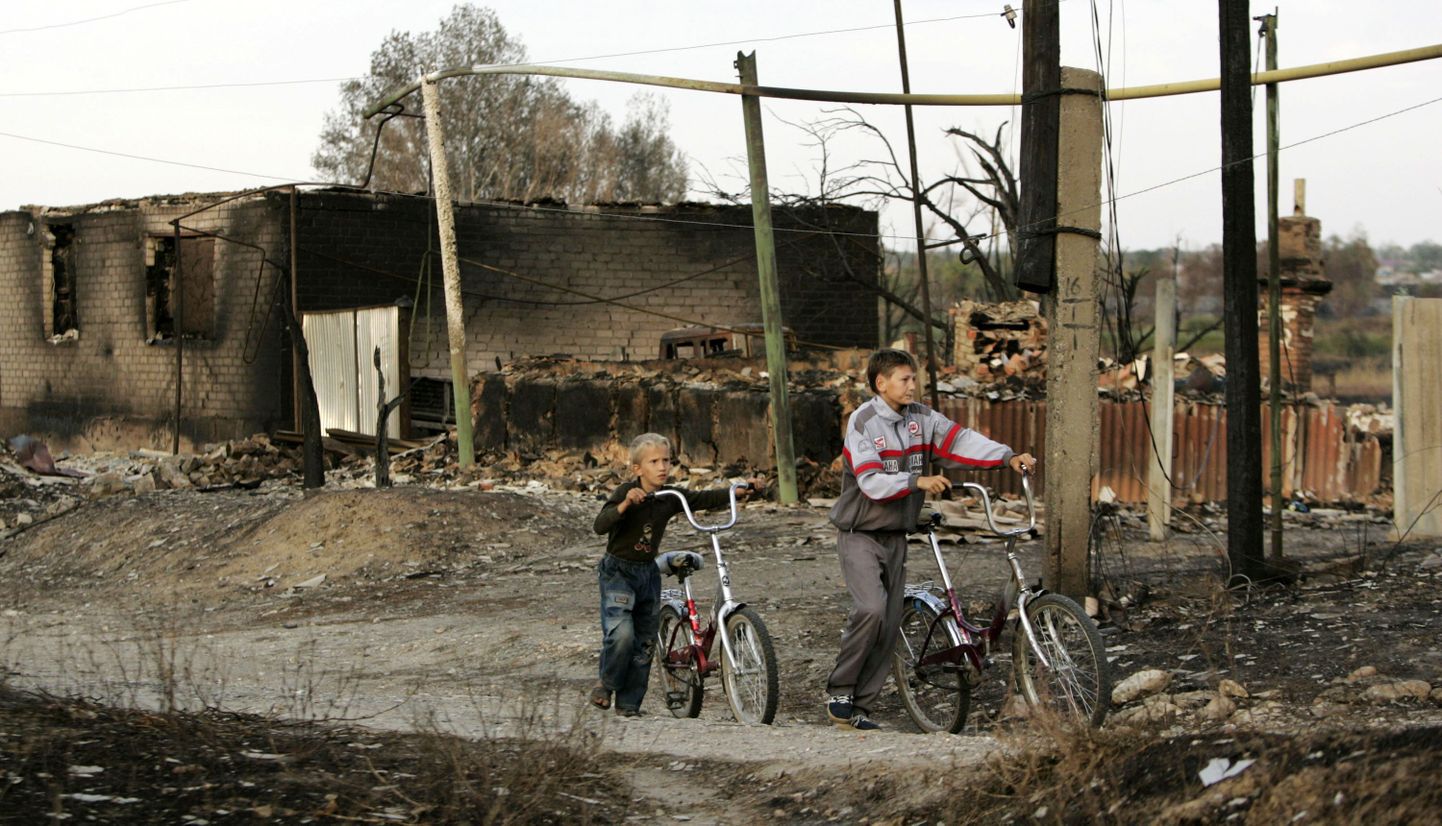 Poisikesed mööduvad põlenud majast Russkaja Budnjovka külas.