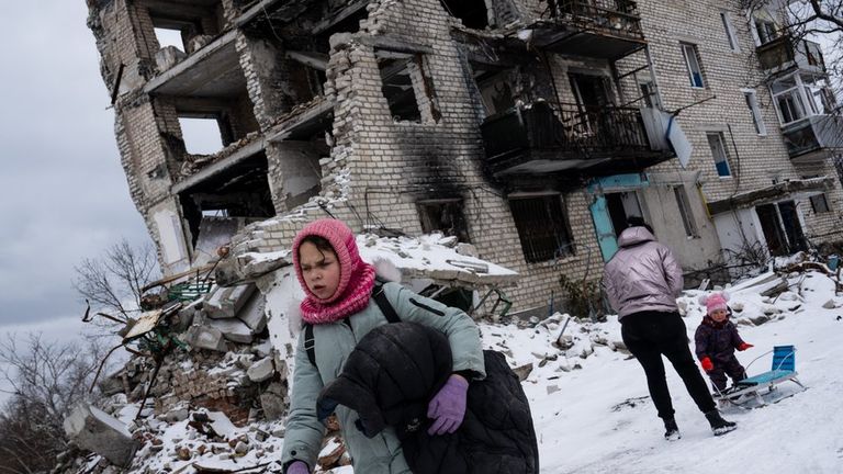 Семья у разрушенного дома в Изюме