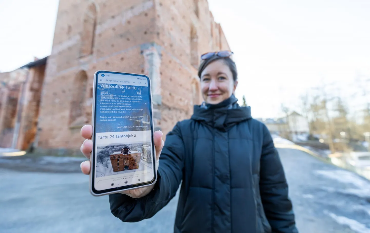 Brita Arnover tutvustab toomkiriku varemete juures oma telefonis avatud kaardirakendust.
