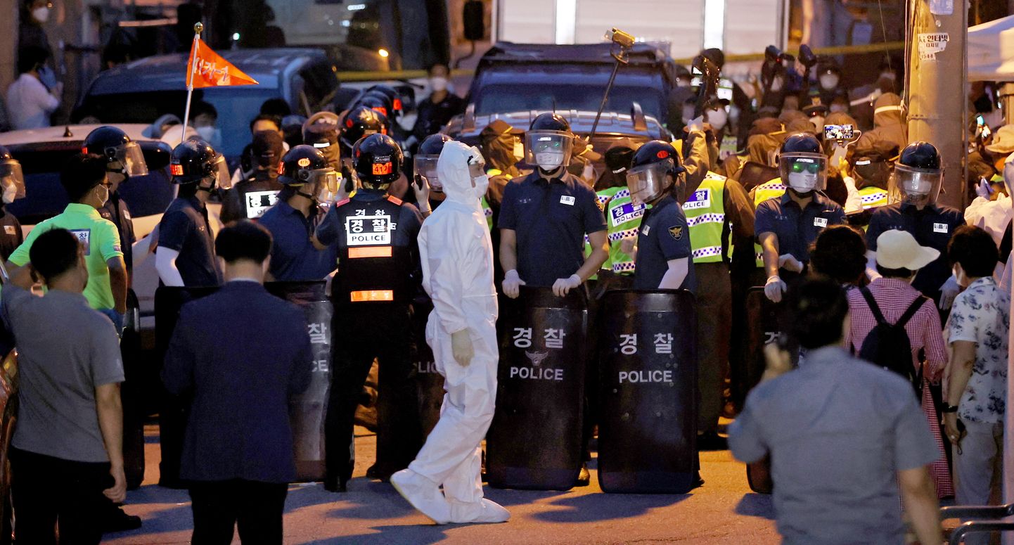 Politseinikud protestivate koguduseliikmetega Sarang Jeili kiriku juures Lõuna-Korea pealinnas Soulis 20 Augustil 2020. Tervishoiutöötajad teevad pingutusi meeleavalduses osalenute tuvastamiseks ja testimiseks, et vältida tänaseks 676ni tõusnud nakatunuga haiguskolde levikut riigi enimrahvastatud linna südames.