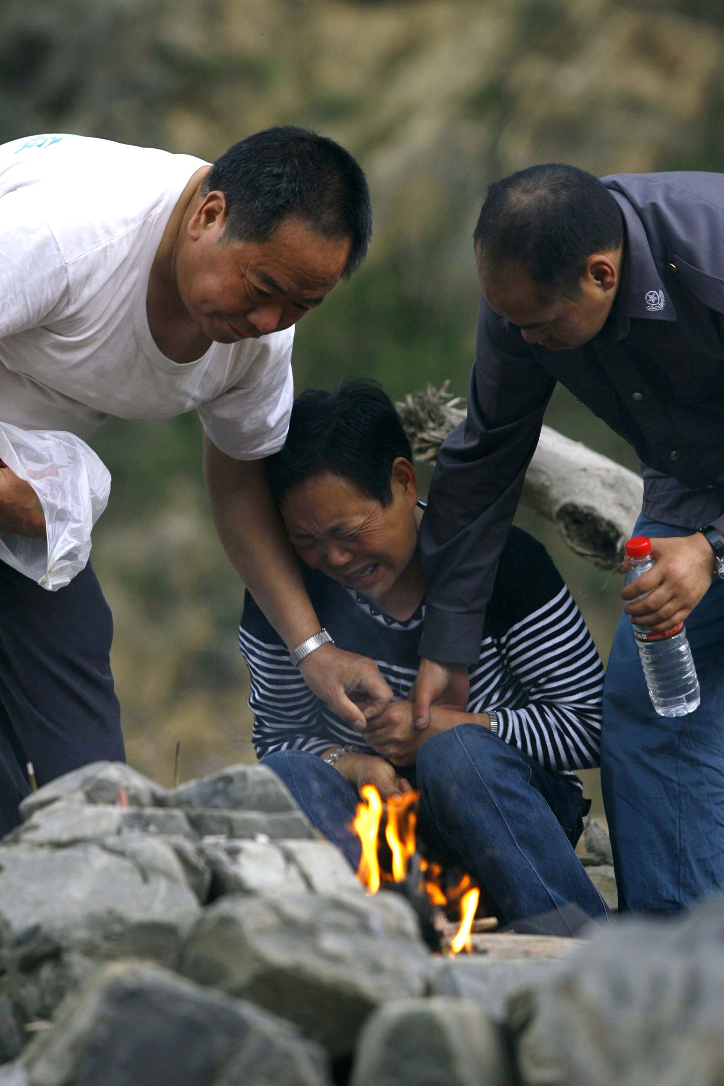 Naine leinab Sichuani maavärinas hukkunud poega ja pojapoega.