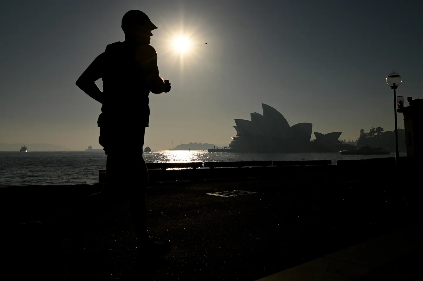 Tervisejooksja Sydney ooperimaja juures. Võimud hoiatasid, et Sydney õhk on maastikupõlengute tõttu saastunud