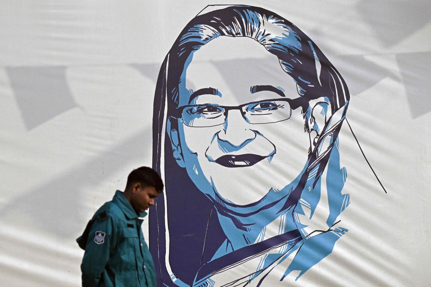 Bangladeshi politseinik Dhakas 8. jaanuaril 2024 möödumas Sheikh Hasina üleelusuurusest plakatist.