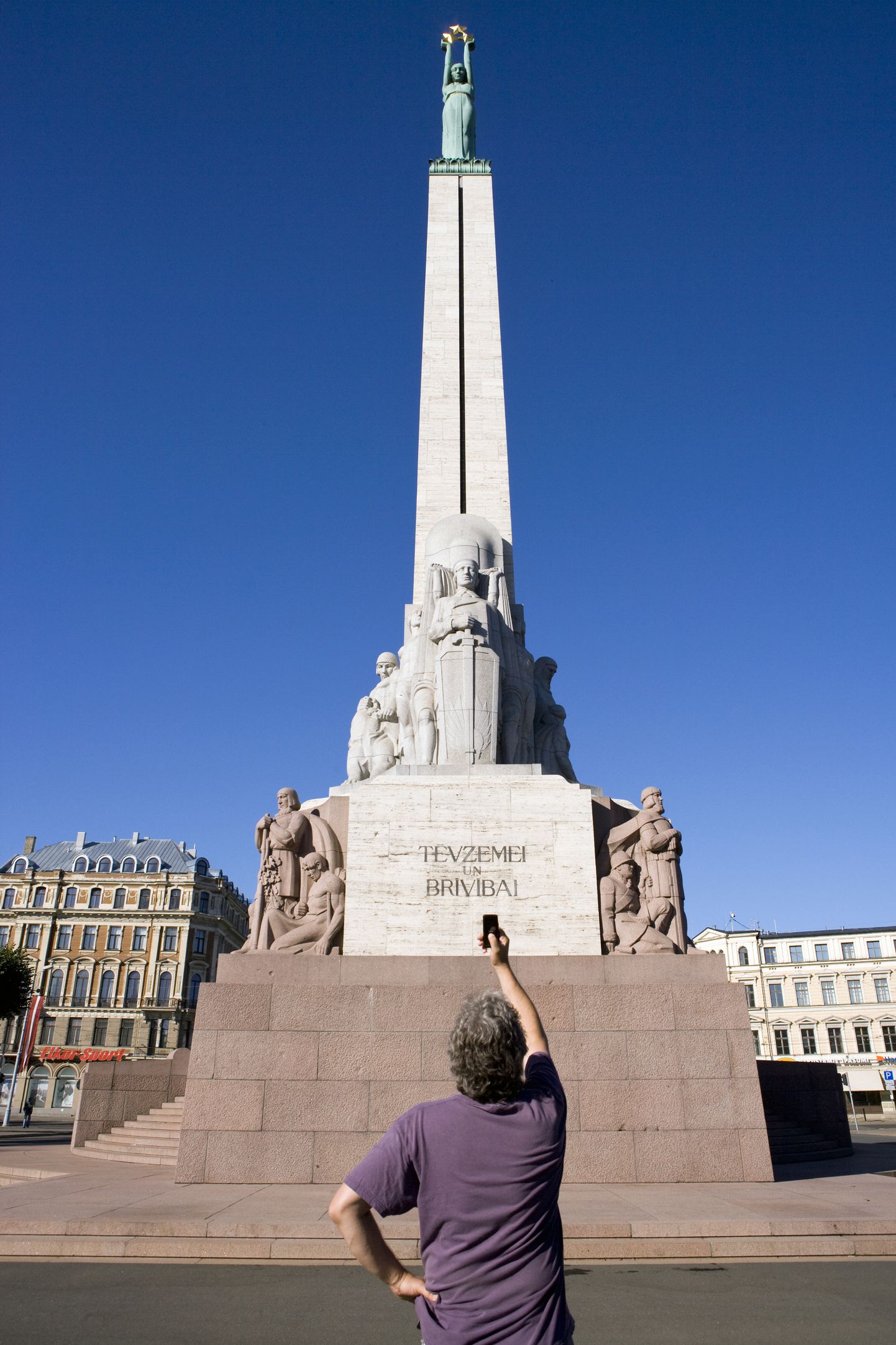 Турист у памятника Свободы в Риге.
