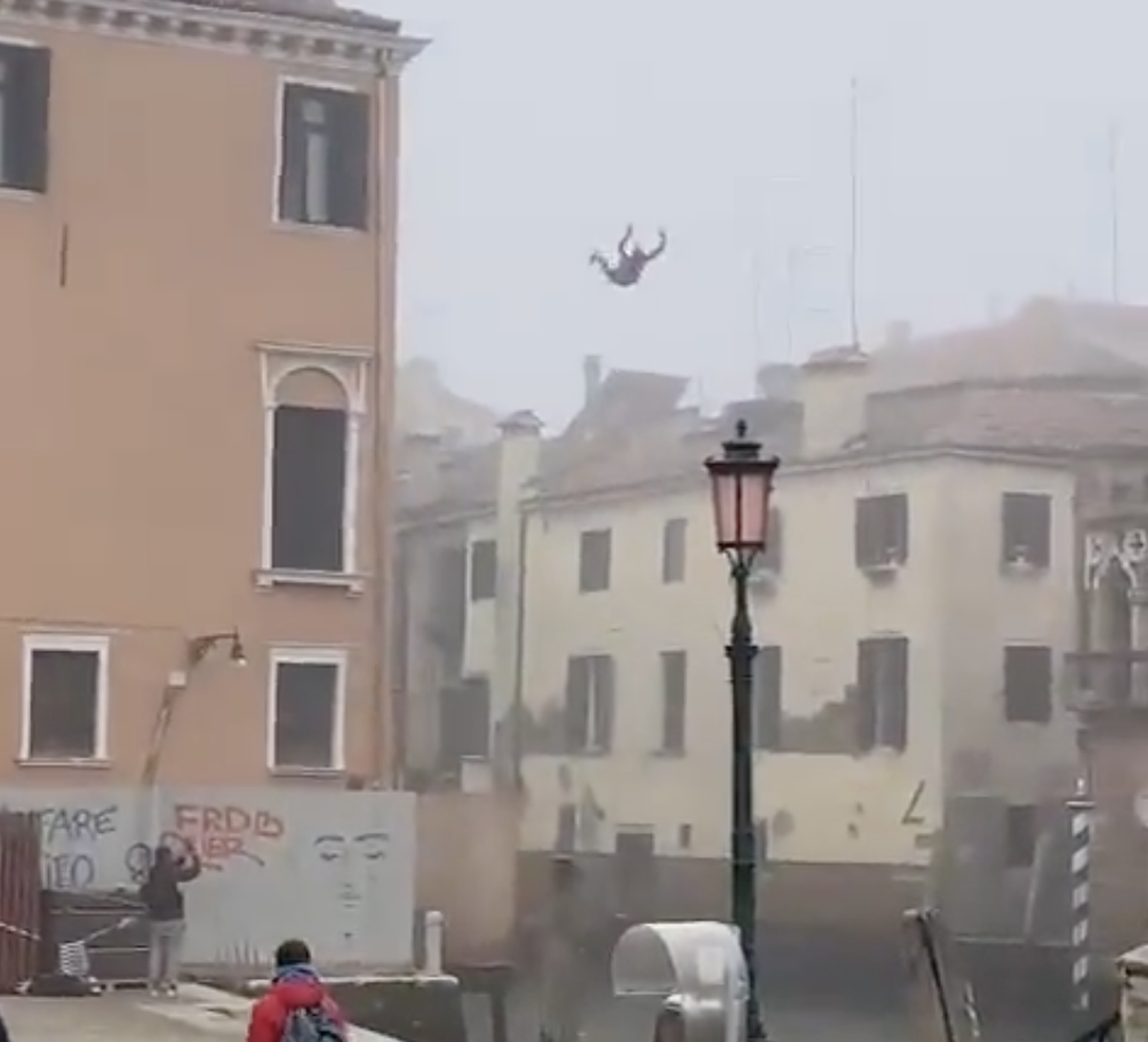 Мужчина прыгает с крыши трехэтажного дома в канал в Венеции