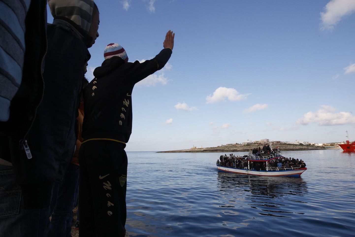 Tuneesia immigrandid tervitavad Lampedusa saarele saabuvat järjekordset põgenikelaeva.