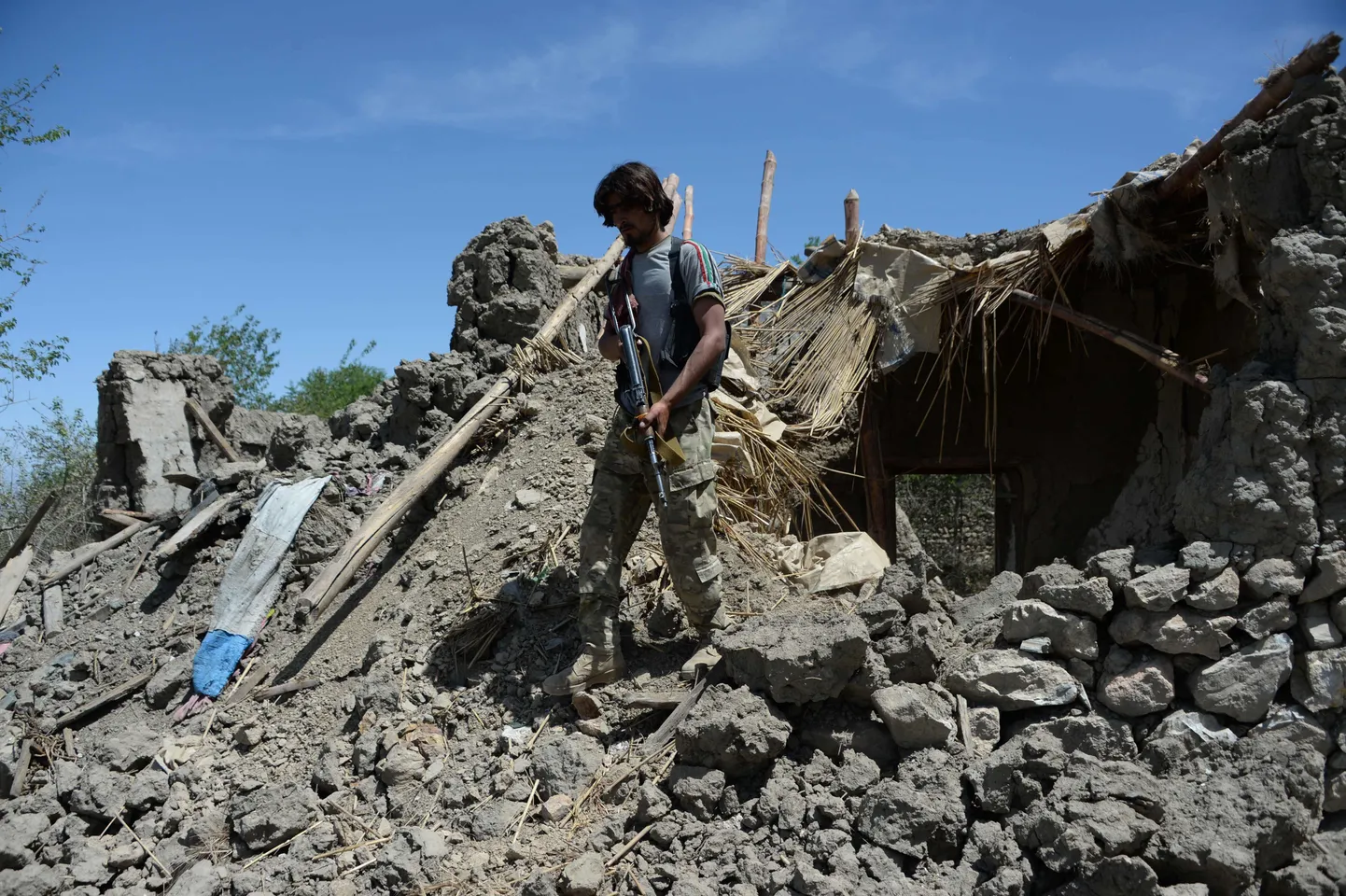 Afgaani sõdur uurib USA pommist tekkinud kahjusid.