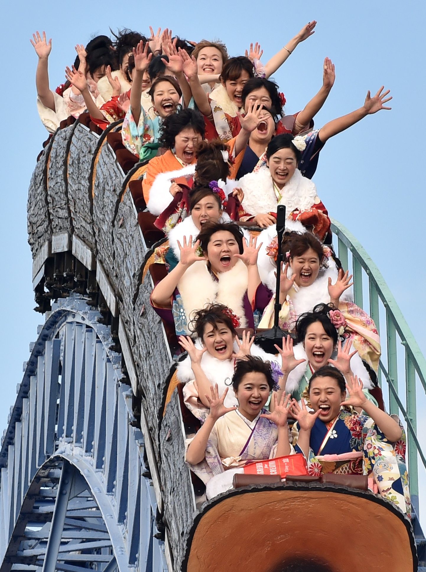 Twenty-year-old women wearing kimonos ride a rollercoaster after attending a "Coming-of-Age Day" celebration at the Toshimaen amusement park in Tokyo on January 11, 2016. The number of people celebrating "Coming-of-Age Day" in 2016, or adulthood - high by world standards at age 20 - is estimated to stand at 1.21 million, a decrease of 50,000 from the previous year. Every January, Japanese turning 20 celebrate Coming of Age Day, in which the new adults dress in formal kimonos, pray at Shinto shrines and hear speeches from local officials on their new responsibilities.     AFP PHOTO / KAZUHIRO NOGI