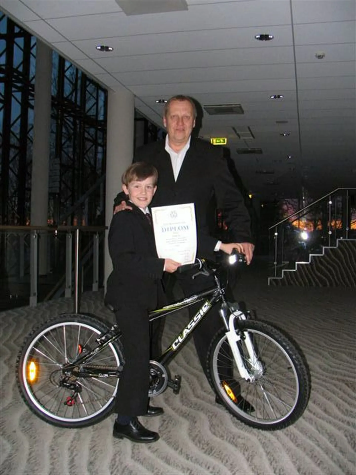 Tauno Tamm koos oma juhendaja Toomas Volli ja võidetud jalgrattaga.