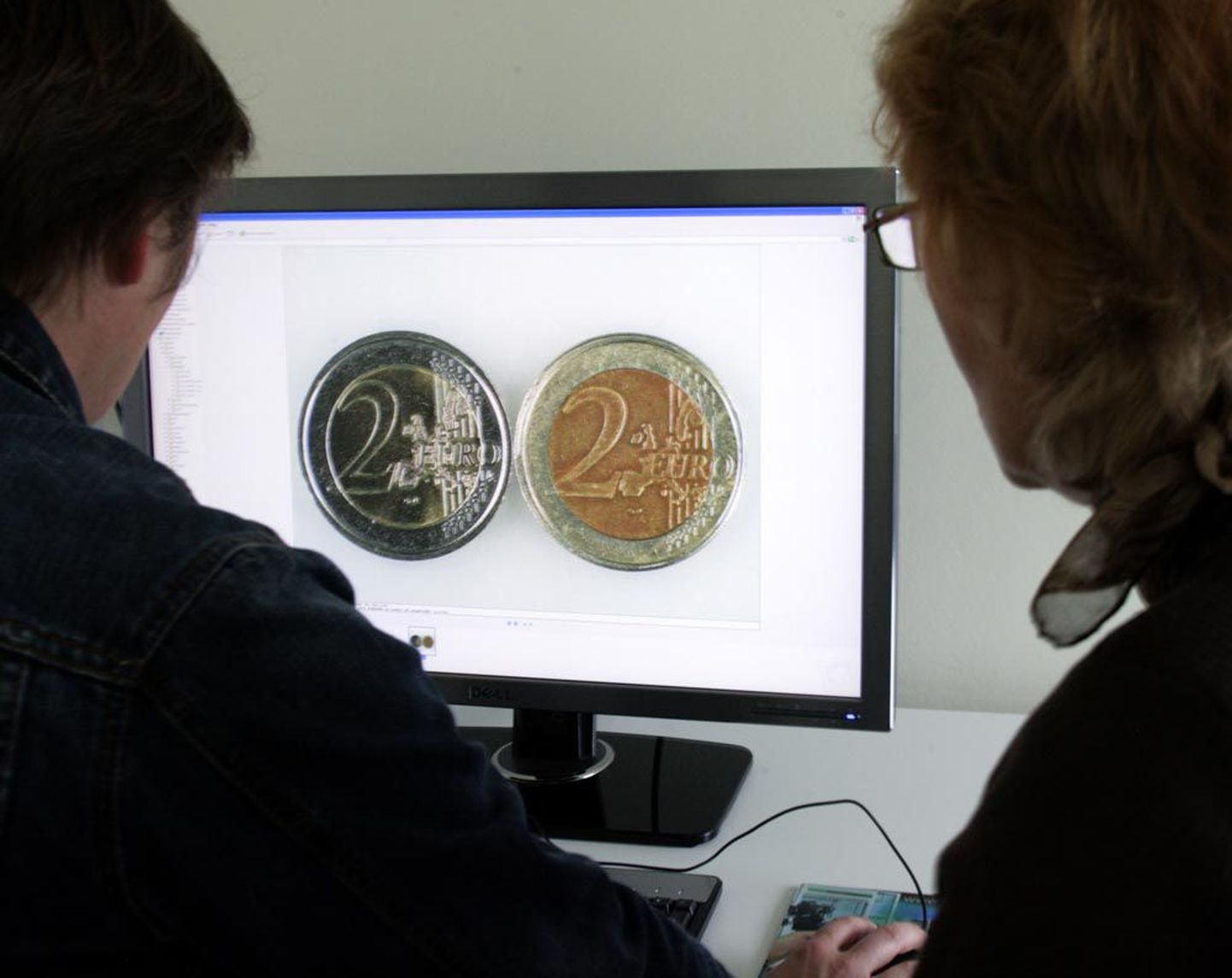 Meelis Toomet (vasakult) ja Kaja Rodi valemünti tuvastamas. Paremal võltsitud euromünt, õige raha on vasakul.