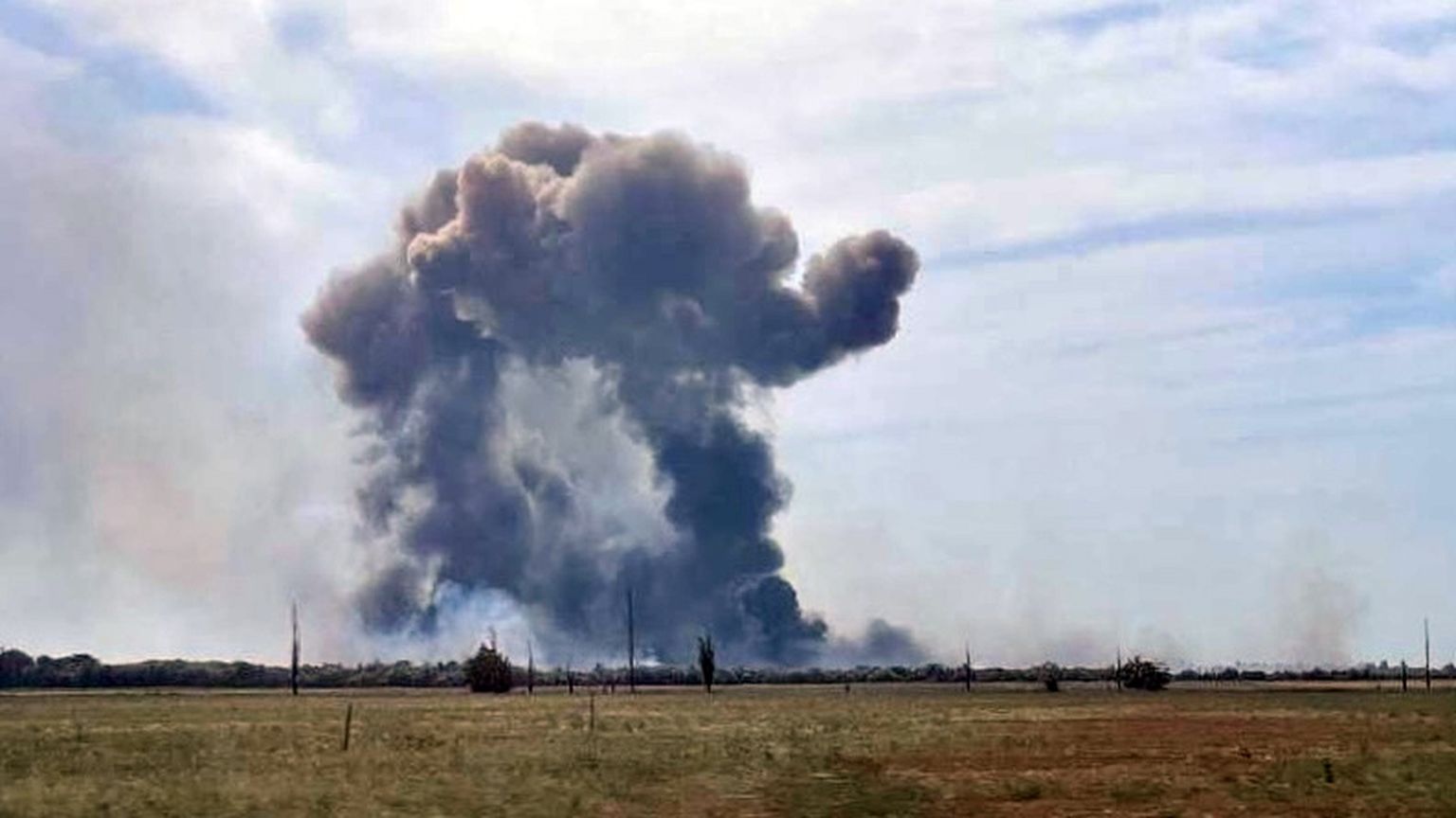 Dūmi, kas paceļas pēc gaisa munīcijas detonācijas Saki lidlaukā netālu no Novofedorivkas, Krimā, 2022. gada 9. augustā