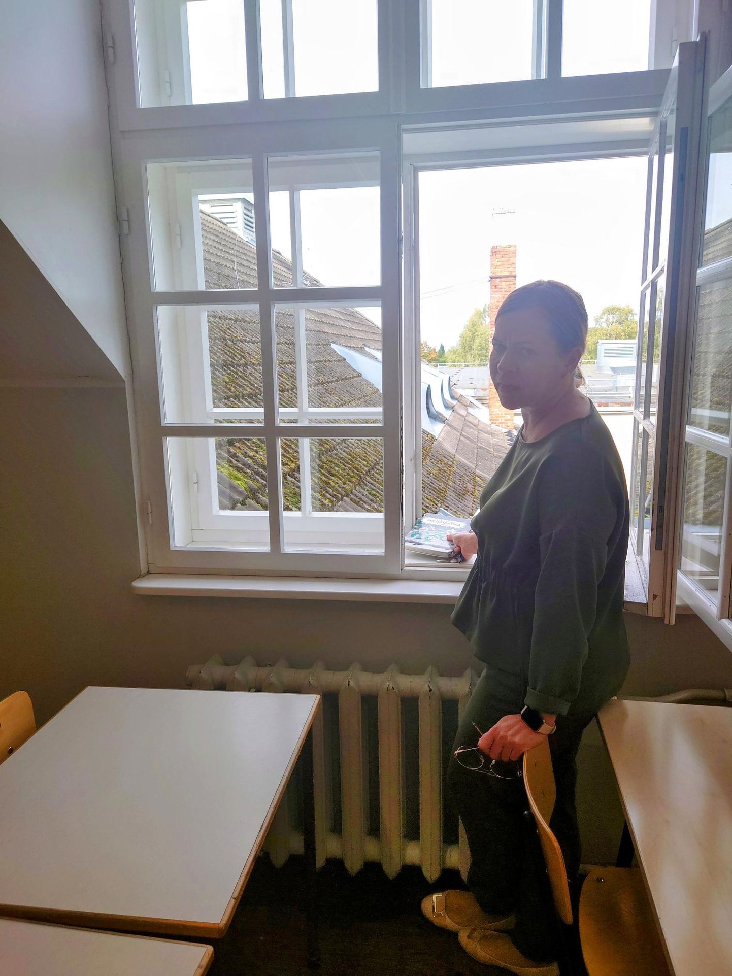 Kooli arendusjuht Tiia Lepik näitas, kuidas aknalauale tõkkeks pandud ja sinna jäänud õpik omamoodi kangina toimis ning akna paigast nihutas.
