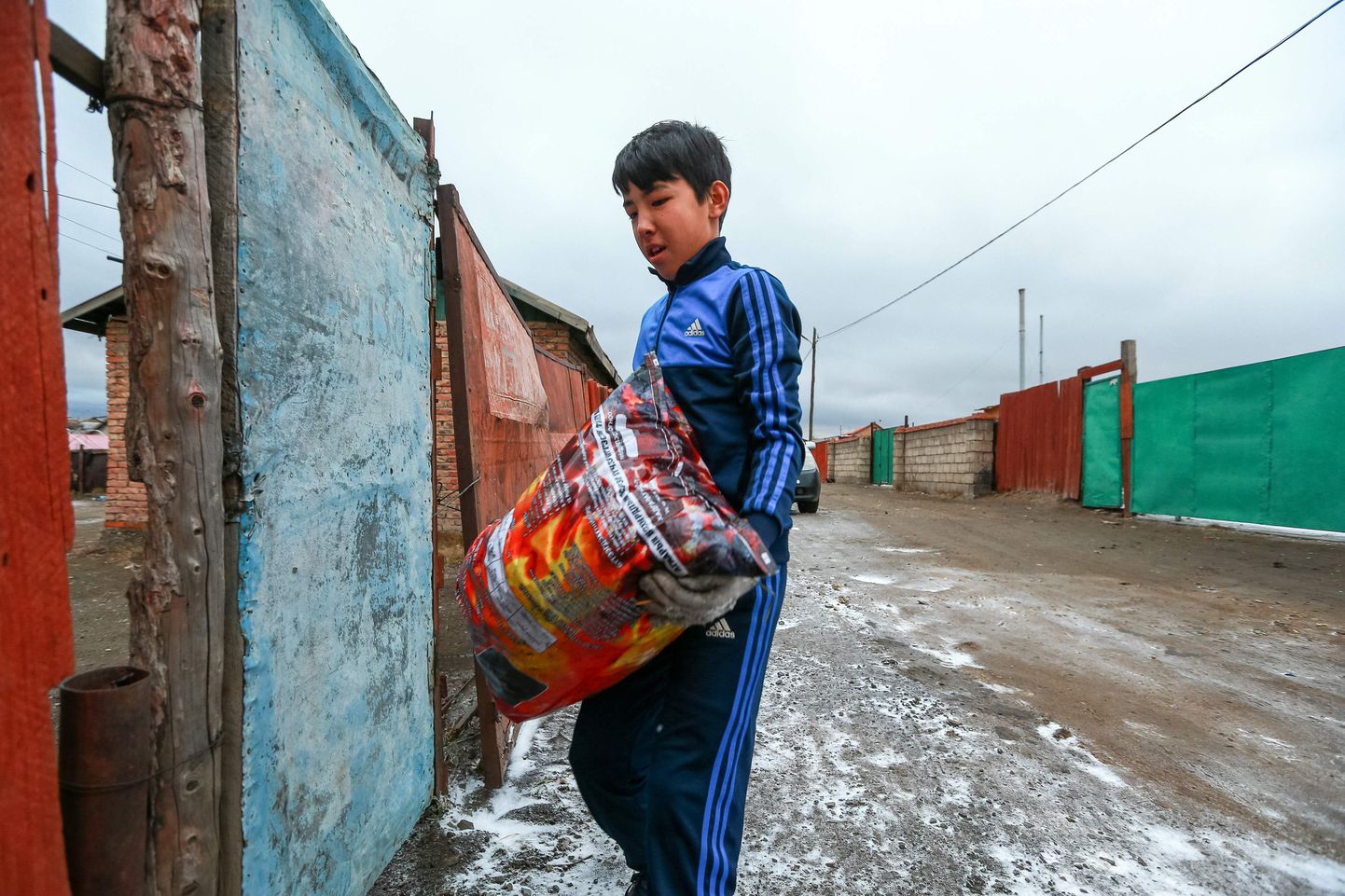 Poiss äsja ostetud koti suitsuvaba briketiga Ulaanbaataris. Uut kütteainet seostatakse ligi kümne inimese surmaga.