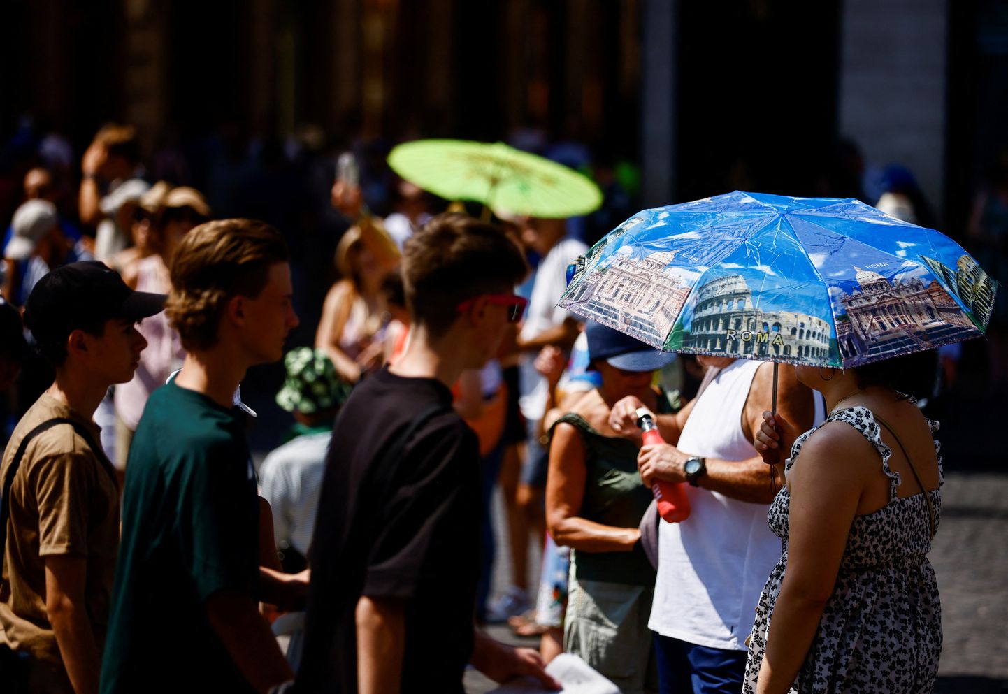 Inimesed kannavad kuumal suvepäeval päikesevarje