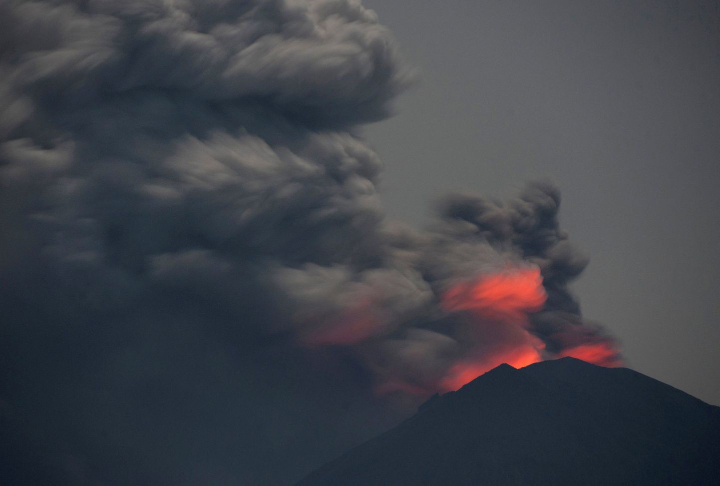 Light from lava inside the crater is reflected off volcanic ash from Mount Agung, as seen from Jemeluk Beach, Karangasem, Bali, Indonesia November 28, 2017 in this photo taken by Antara Foto. Picture taken November 28, 2017. Antara Foto/Nyoman Budhiana/via REUTERS ATTENTION EDITORS - THIS IMAGE WAS PROVIDED BY A THIRD PARTY. MANDATORY CREDIT. INDONESIA OUT.     TPX IMAGES OF THE DAY