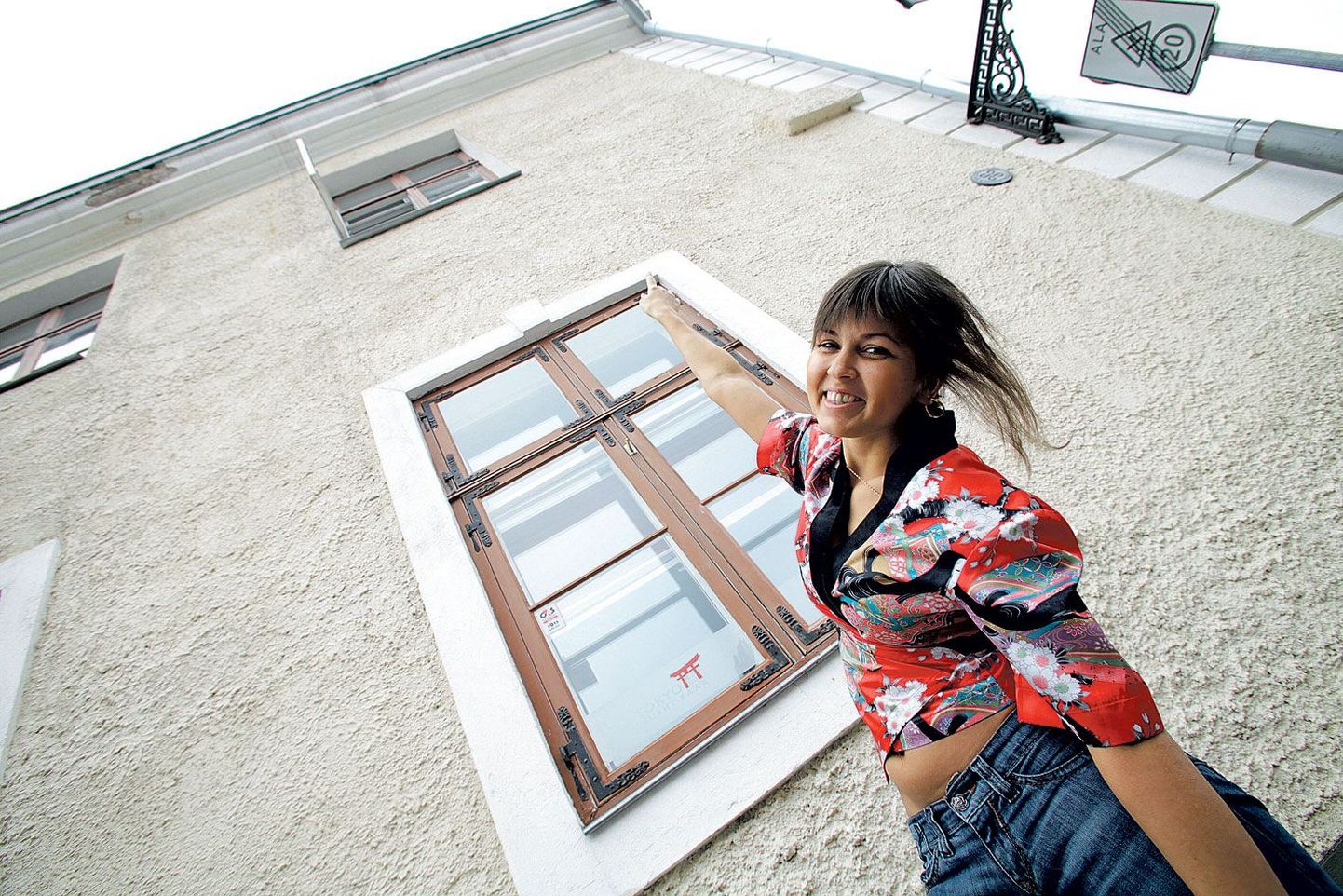 Jaani 20 maja sushi-baaris töötav Viktoria Verkina osutab pragudele maja fassaadil.