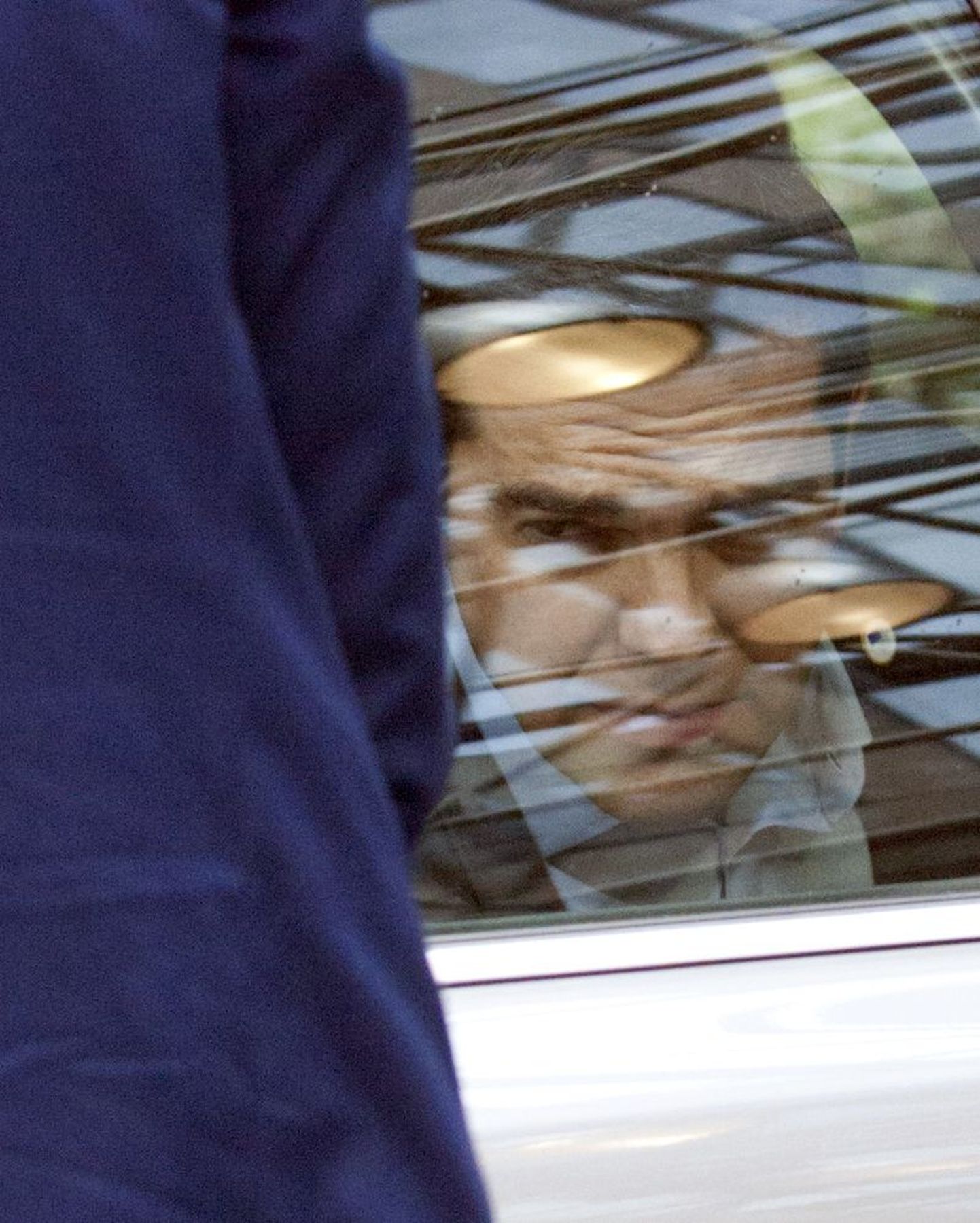 Ципрас выглядывает из окна автомобиля в преддверии встречи с членами Еврогруппы.