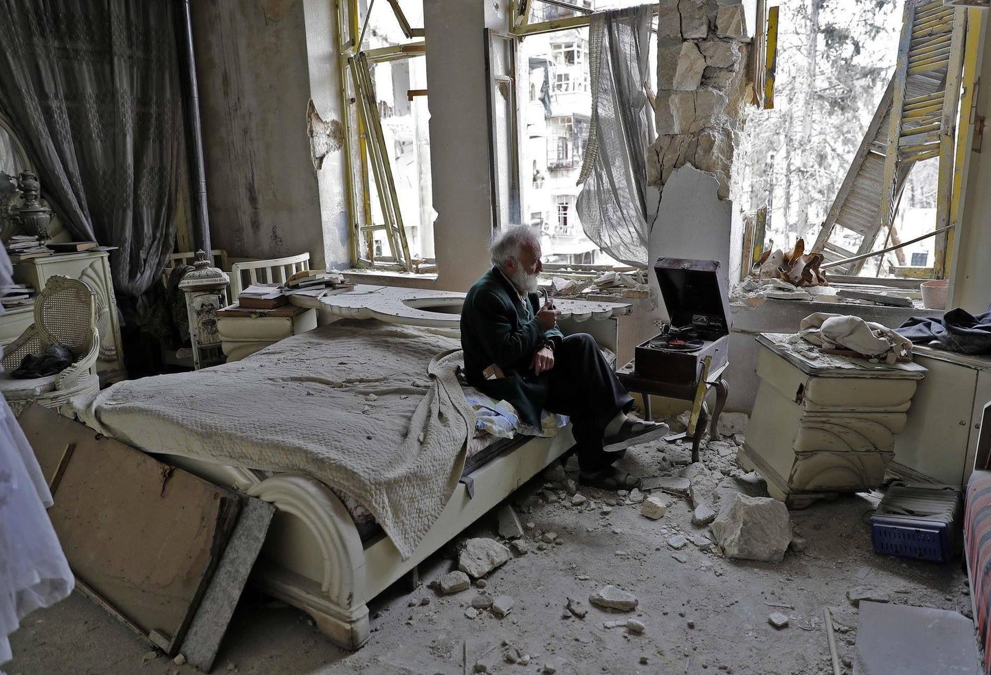 M.Mohiedine Anis (70) suitsetab piipu ja kuulab muusikat oma hävitatud magamistoas Aleppos