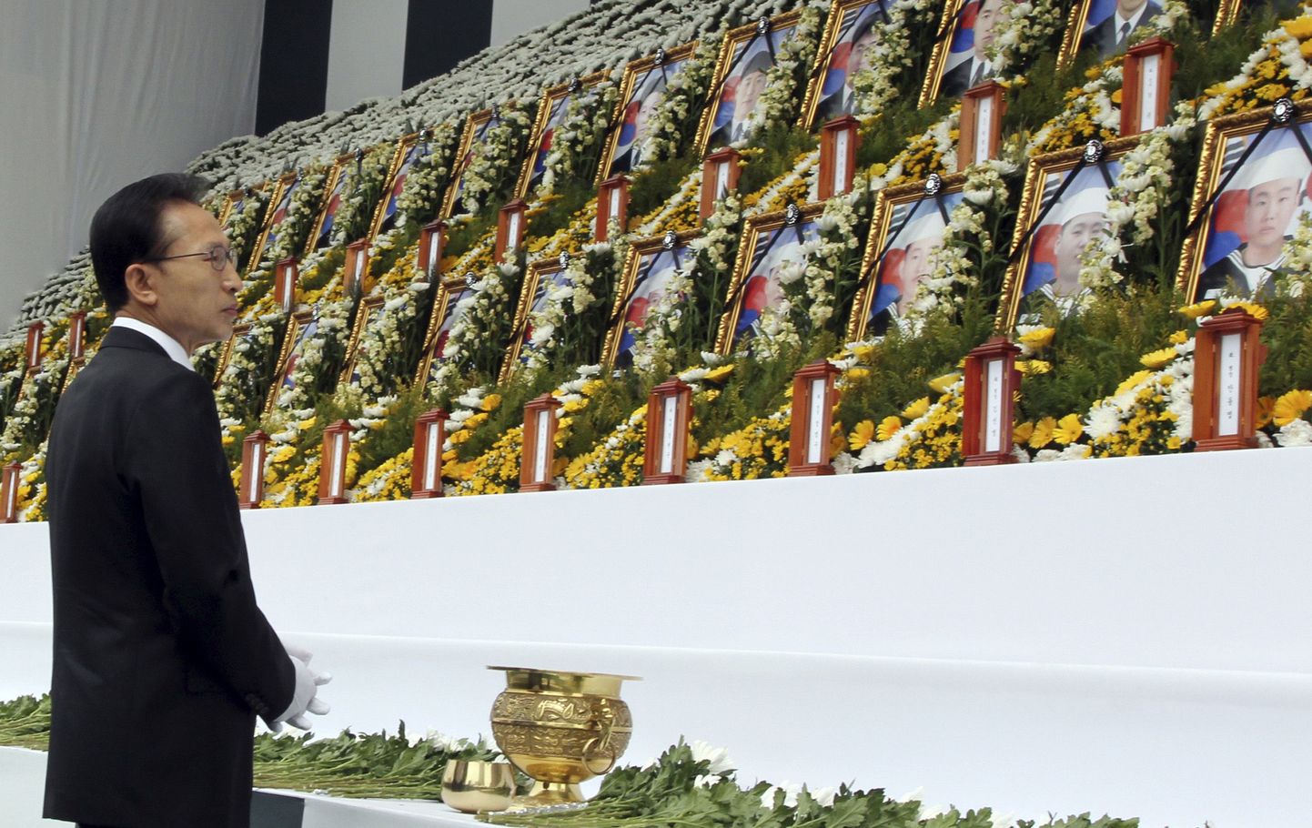 Lõuna-Korea president Lee Myung-Bak hukkunud sõjameeste portreepilte vaatamas.