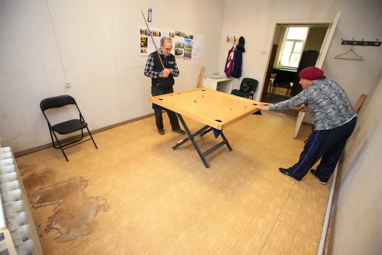 Koroonamängutoas on laua taga Feodor Tootsi ja Marta Ruus. Esiplaanil veeloigukoht.