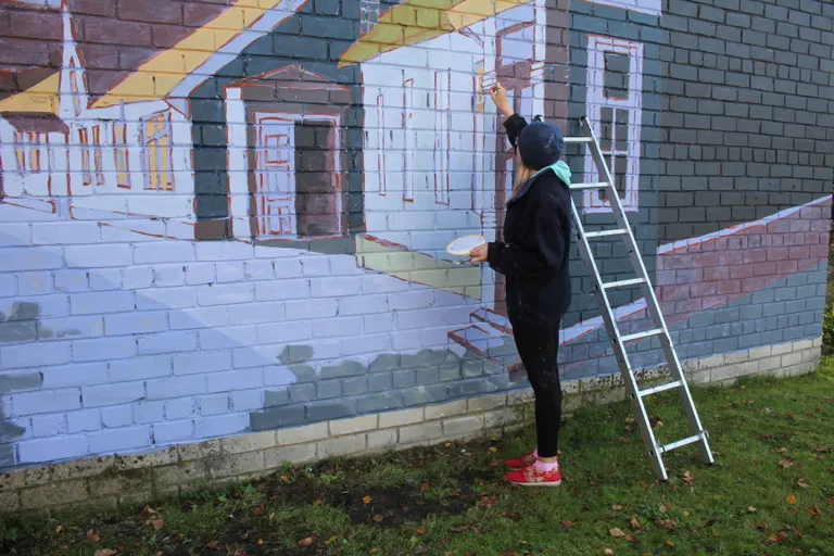 Kunstnik Liina Talts maalimas Paides alajaama seinale.