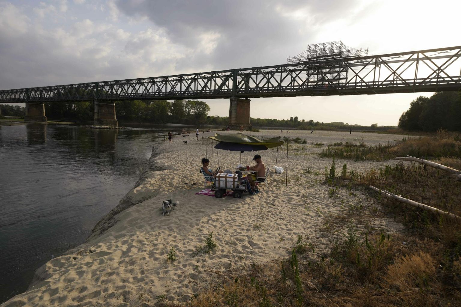 Inimesed naudivad päikesepaistet veest kuivaks jäänud Po jõe põhjal Pavia lähistel Linarolos.