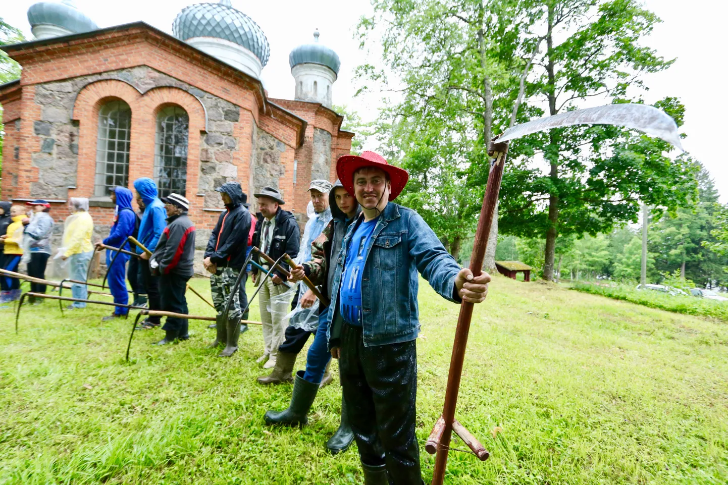 Täpselt kell 13.00 seisid kiriku taga poolkaares vikatitega tegelased, mõnel kaabu peas, kilemantel või ülikond seljas, ning olid valmis vaatamata vihmale ja tormile asuma võistlusse pärandkultuuri säilimise nimel.