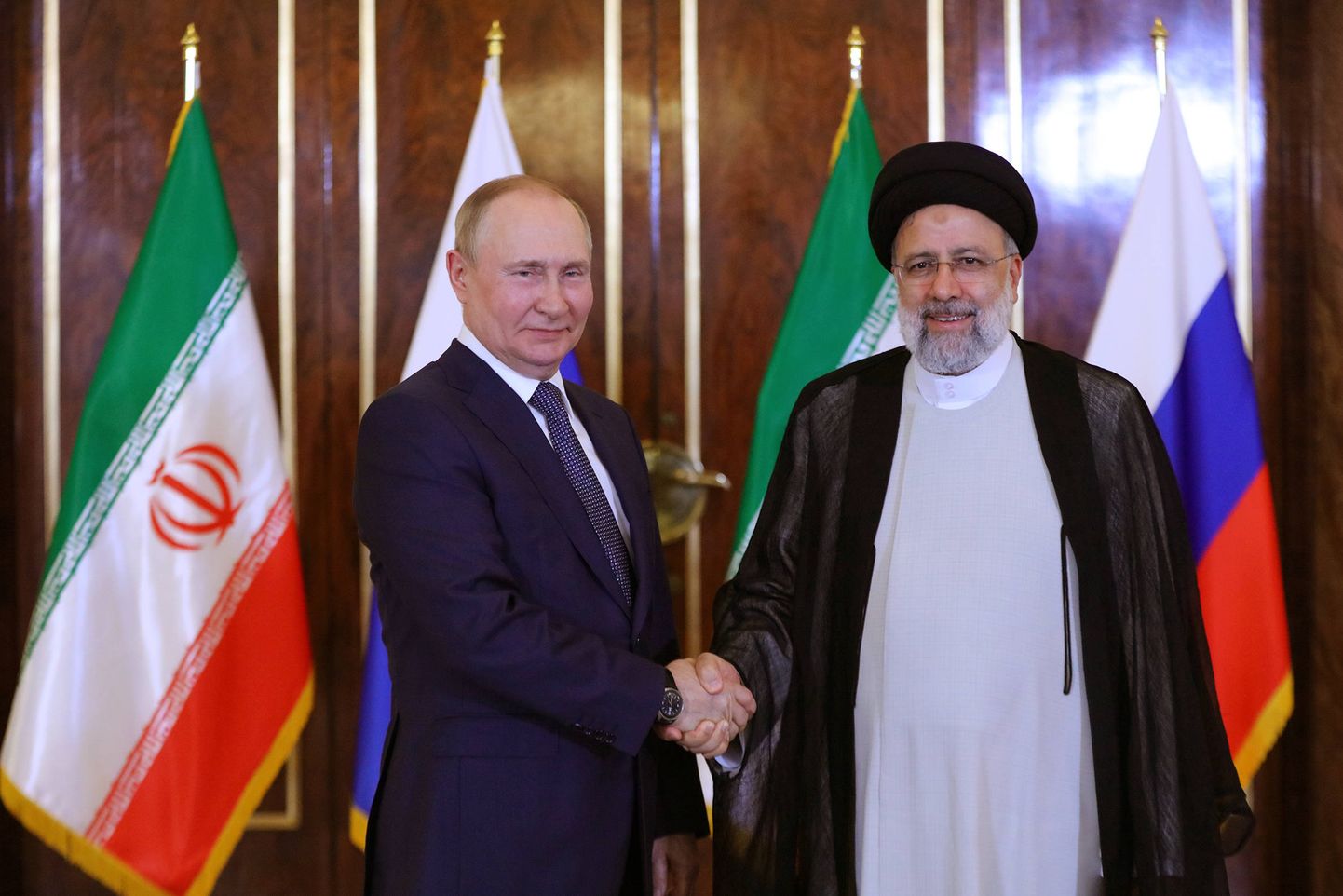 Президент Ирана Эбрагим Раиси и Путин радуются друг другу в Тегеране, обсуждая вопросы безопасности в ходе первой поездки президента РФ за границу за долгое время. Июль 2022 года.