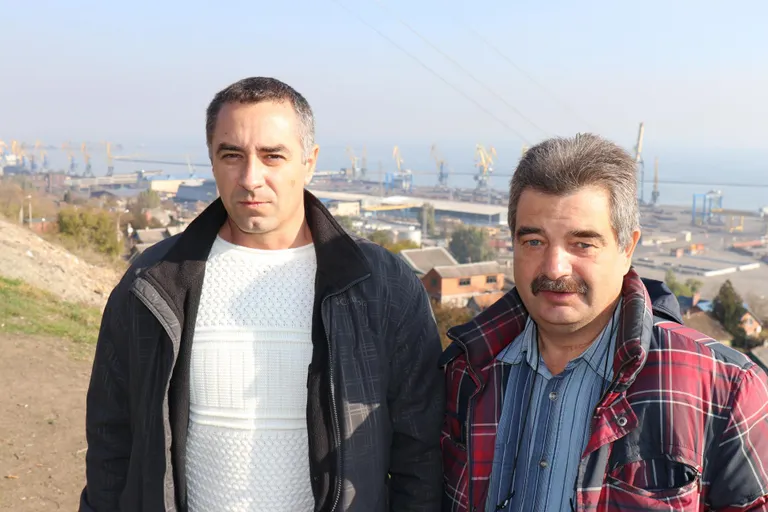 Крановщик Мариупольского порта Евгений Марковский и грузчик того же порта Олег Гусак.