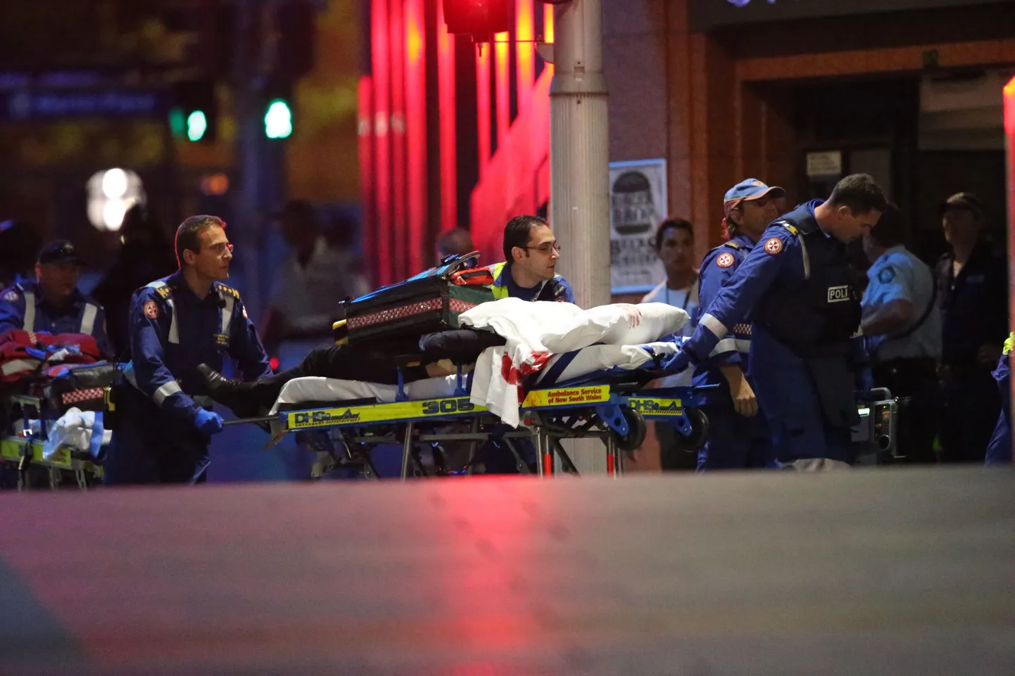 Австралийские медики везут на носилках раненого заложника.