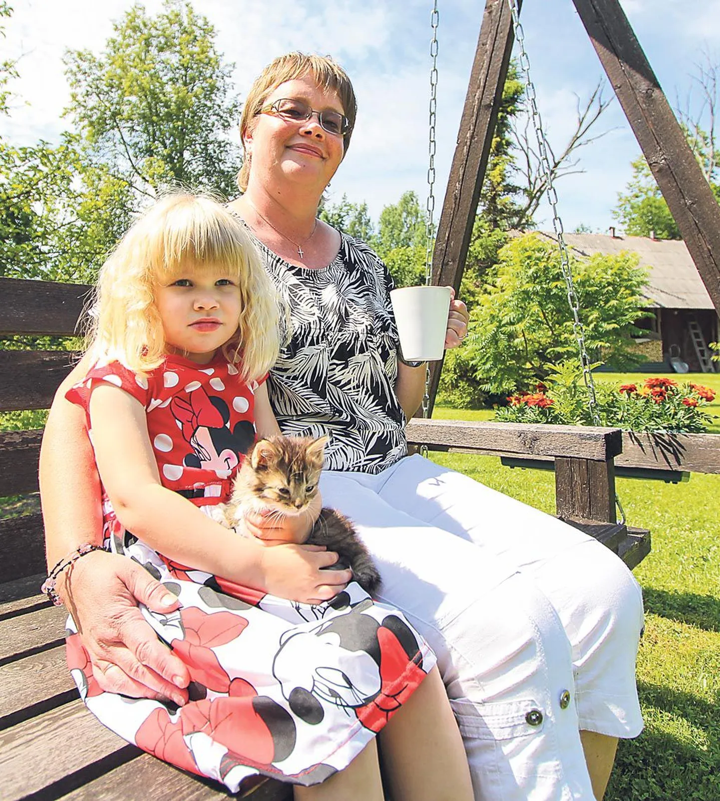 Riitskulli talu perenaine Õnnela Teearu istus koduaias kiigele koos oma silmatera, neljase tütretütre Keitliniga.