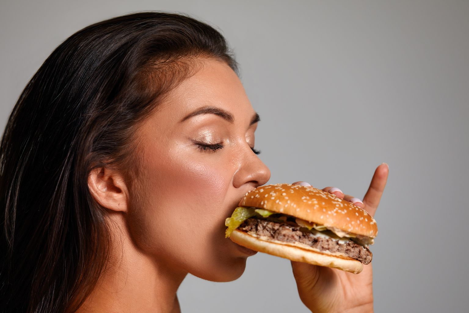 Девушка ест гамбургер. Иллюстративное фото