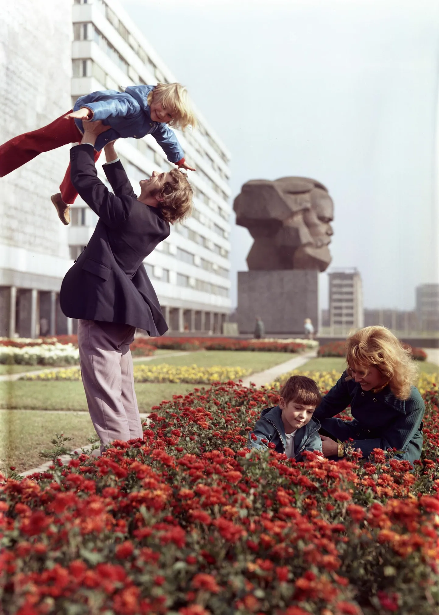 Lääne pool raudset eesriiet loeti Karl Marxi hoole ja armastusega, ida pool tuli seda teha kohustuslikus korras. Pildil on ida-saksa perekond 1975. aastal, taustal maailma suurim Karl Marxi monument Chemnitzi linnas, mille nimi oli toona Karl-Marx-Stadt.