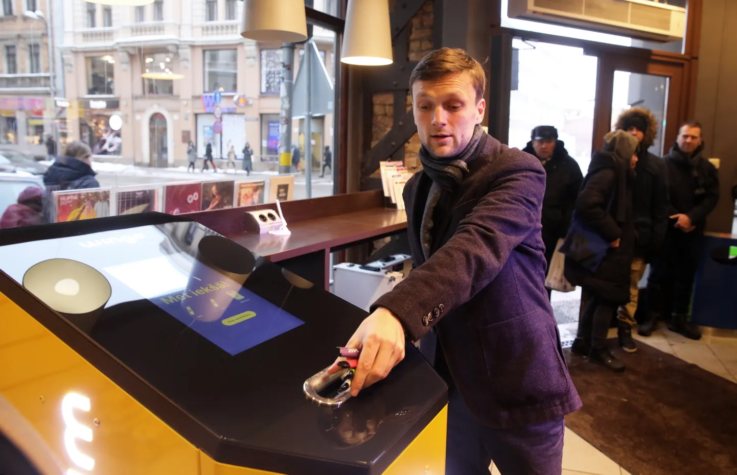 "Wingo Deposit" līdzīpašnieks un viens no "Wingo" idejas autoriem Vismands Menjoks piedalās Latvijā radītās e-cigarešu un bateriju depozīta sistēmas iekārtas atklāšanas pasākumā "Narvesen" veikalā Barona un Dzirnavu ielas krustojumā.