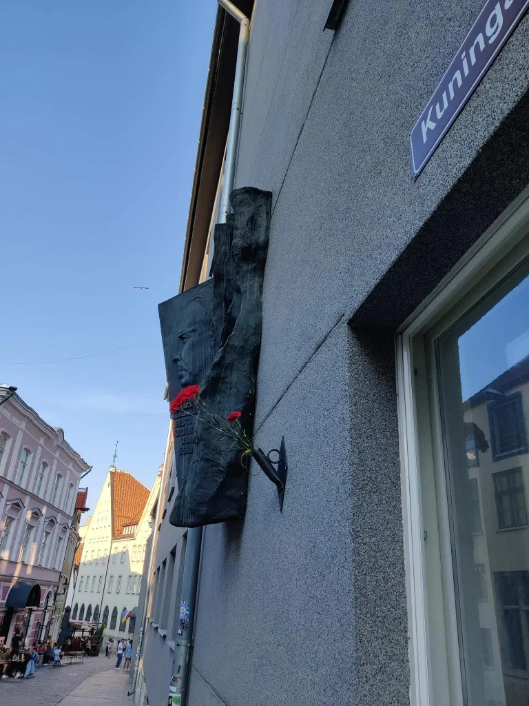 Красные гвоздики возле барельефа писателя Смуула в центре Таллинна.