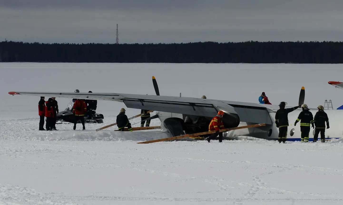 Спасатели укрепляют самолет брусьями перед началом буксировки.