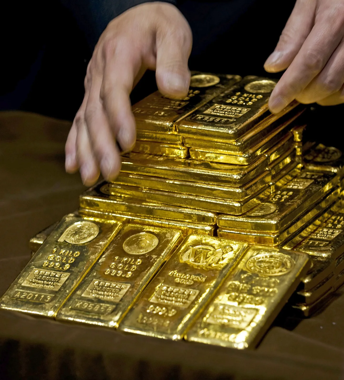 FILE - In an Oct. 17, 2011, file photo a staff member displays gold bullion bars during a news conference at the Chinese Gold and Silver Exchange Society in Hong Kong. A new study based on observations from space suggests the gold on Earth came from colliding dead stars in a cataclysmic event that occurred long ago. The research by the Harvard-Smithsonian Center for Astrophysics will appear in a future issue of the Astrophysical Journal Letters. (AP Photo, File) / SCANPIX Code: 436