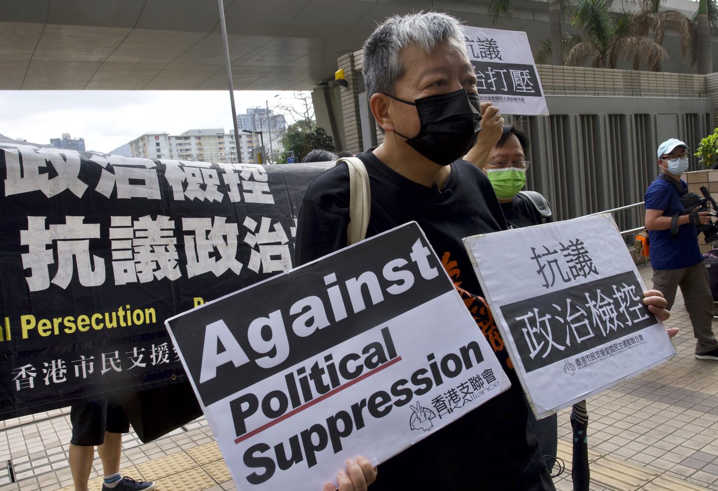 Üks süüdimõistetutest, Lee Cheuk-yan hoidmas täna käes plakateid, mis soovivad poliitilise tagakiusamise lõppu.