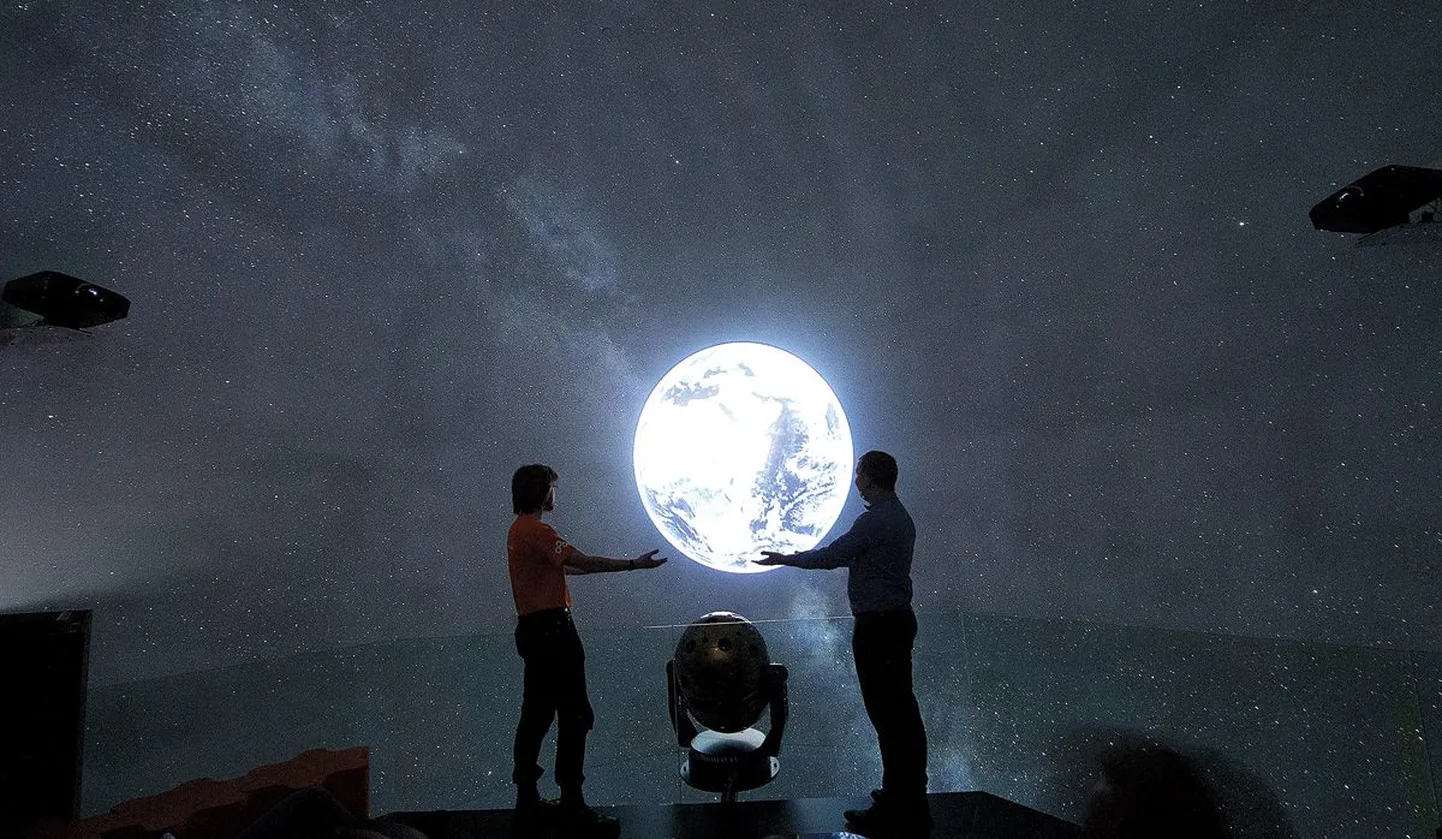 Ahhaa planetarist Üllar Kivila ning keskuse turundus- ja kommunikatsioonijuht Mathis Bogens võtsid uuenenud planetaariumis õrnalt kätele sini-rohelise maakera. Nende vahele jääb aga ereda leedvalgusega optiline kera, mis võimaldab tähistaevast senisest teravamat pilti näidata.