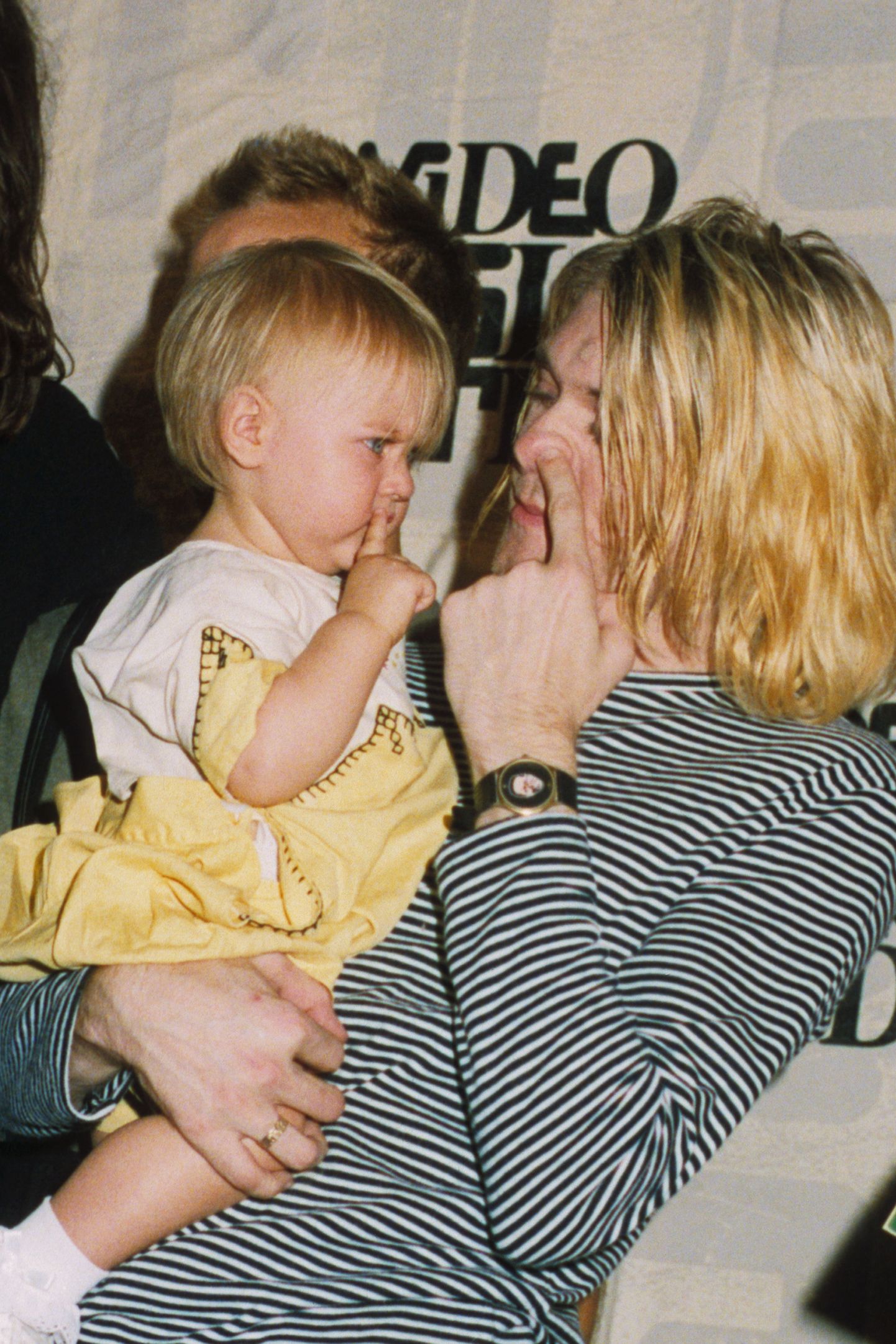 Kurt Cobain, frontman with the band Nirvana, pretends to pick his nose with daughter Frances Bean.