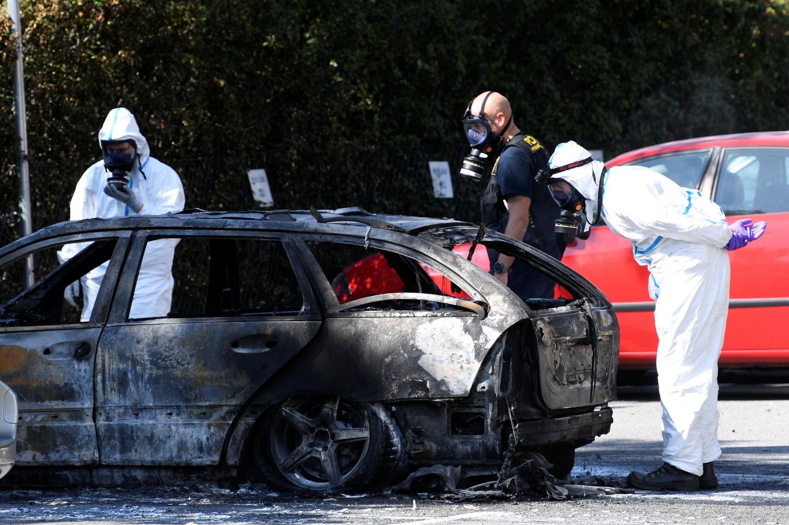 Rootsi politseinikud ja kriminalistid uurivad Malmös 31-aastase naise tapmispaiga lähedal põlema pandud autot. 