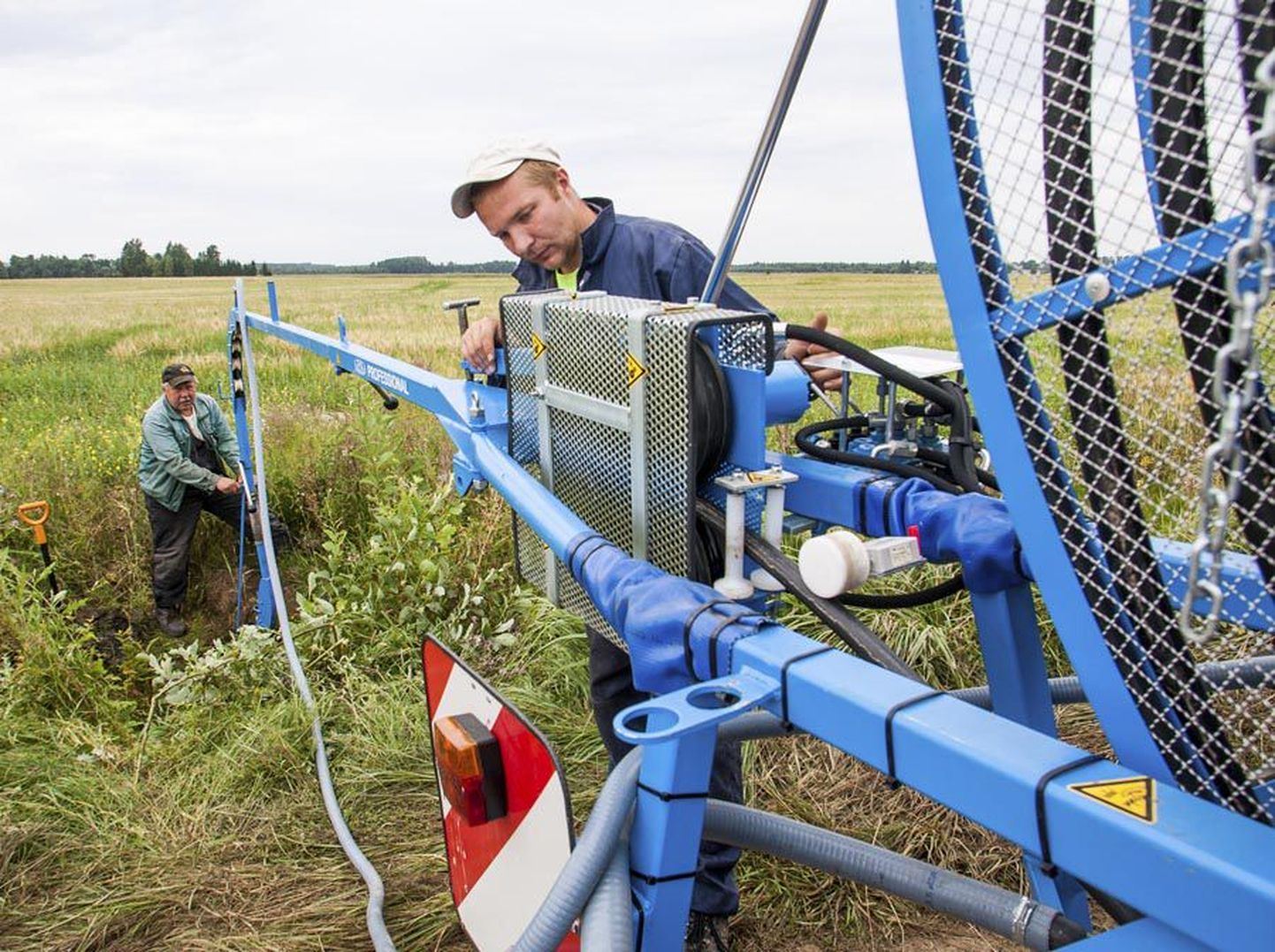 Töömehed Kullar Hunt (taga) ja Kunnar Hunt (ees) sätivad Eestis vähe levinud drenaažipesumasinat, et pesta puhtaks Kaarli küla maaparandus-arendusühingu põldude kuivendussüsteemi torud.