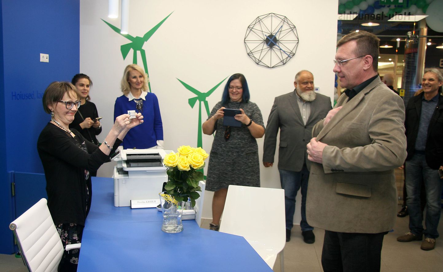 Руководитель новой конторы Марика Крейлис (слева) вручает визитку первому вкладчику в этот день - нарвскому предпринимателю Андрусу Тамму.