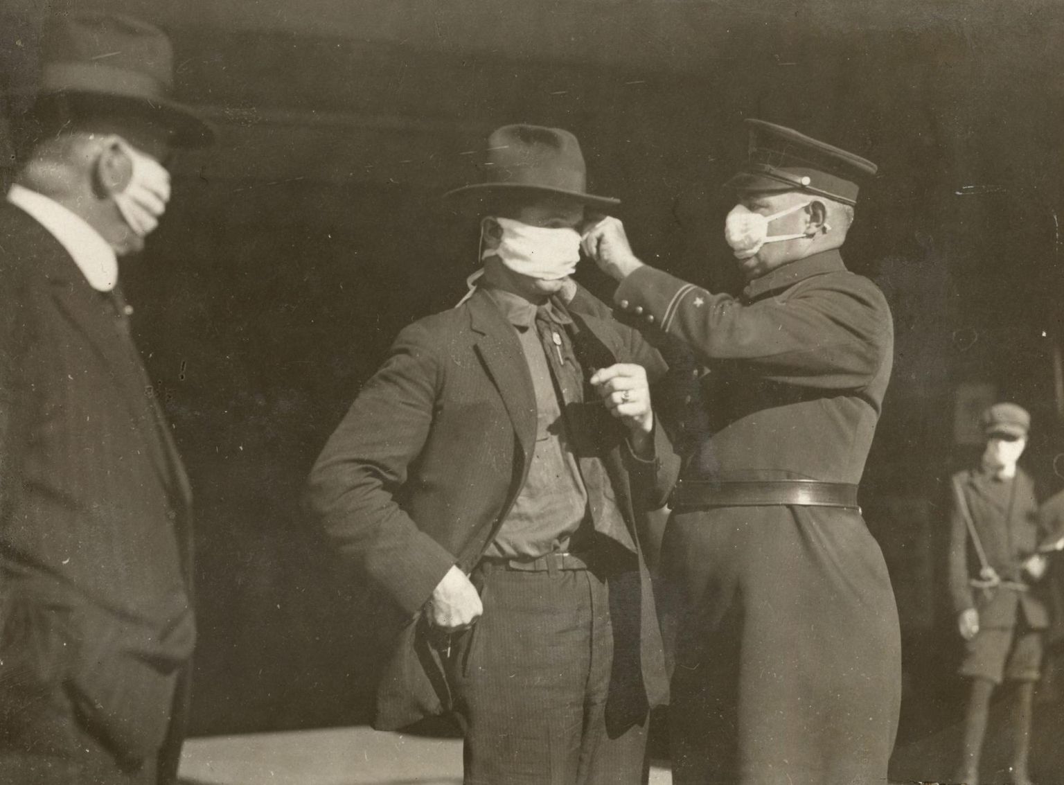 San Francisco politseinik abistab elanikku maski kasutamisel 1918. aastal Hispaania gripi pandeemia ajal.