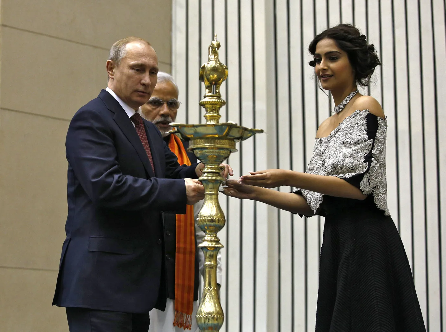 Bollywoodi näitleja Sonam Kapoor aitab  Vladimir Putinil traditsioonilst õlilampi süüdata. Taustal India peaminister Narendra Modi.